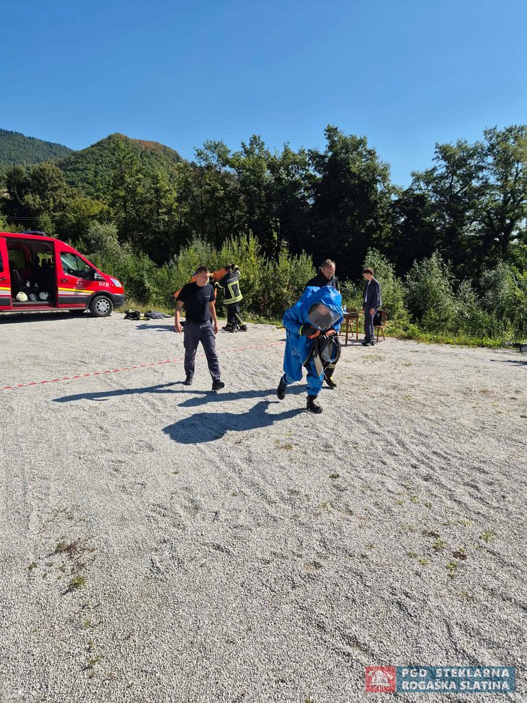 Tekmovalec v modri zaščitni obleki med vajo na utrjeni površini.